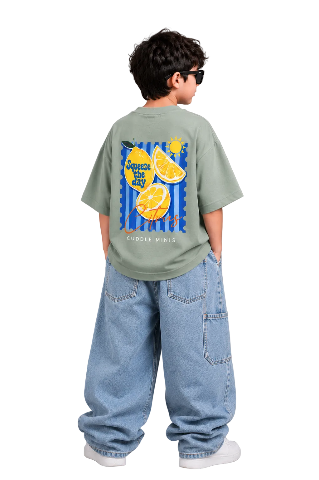 Child wearing a green t-shirt with lemon design and blue jeans on a gray background
