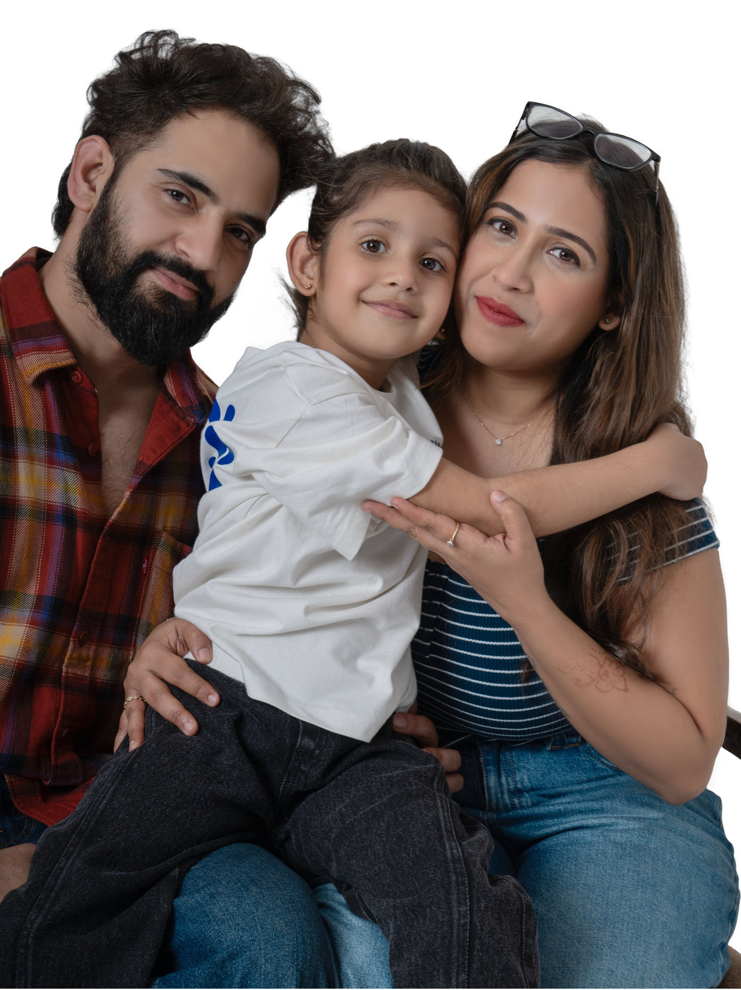 Family of three sitting together on a white background